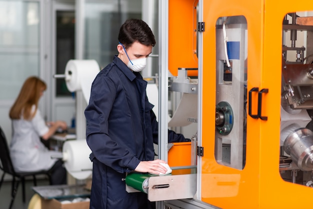 Un lavoratore in una fabbrica per la fabbricazione di maschere mediche