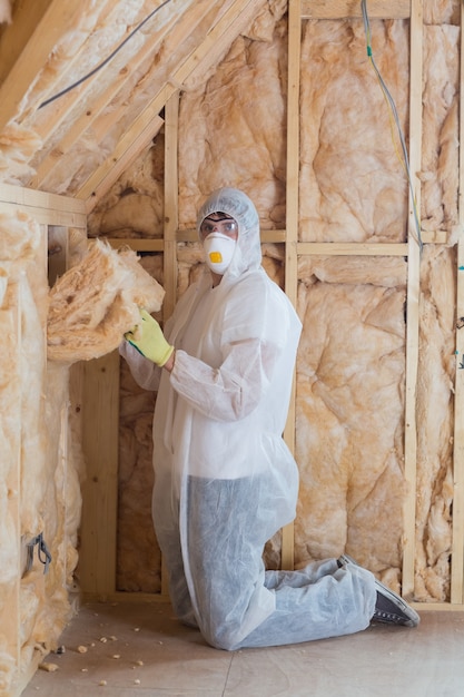 Worker filling walls with insulation