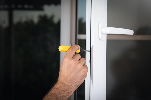 Finestra di fissaggio del lavoratore con cacciavite installazione di una nuova finestra di plastica in casa