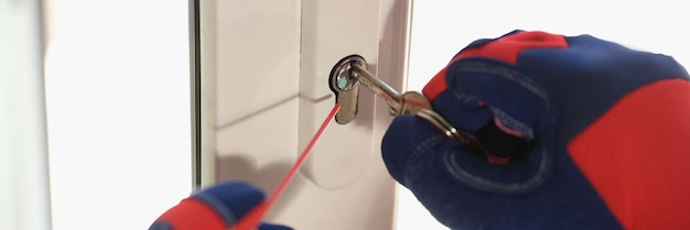 Worker in gloves checks lock in new plastic door or window repair and maintenance of locks