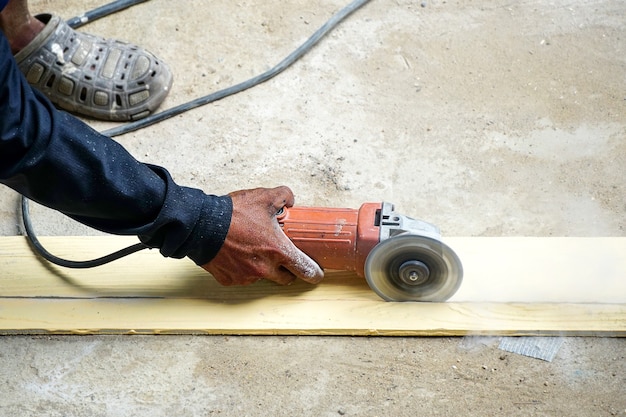 작업자는 단단한 바닥을 갈고 고전단 그라인더로 작업자는 인조 목재 절단을 절단합니다.