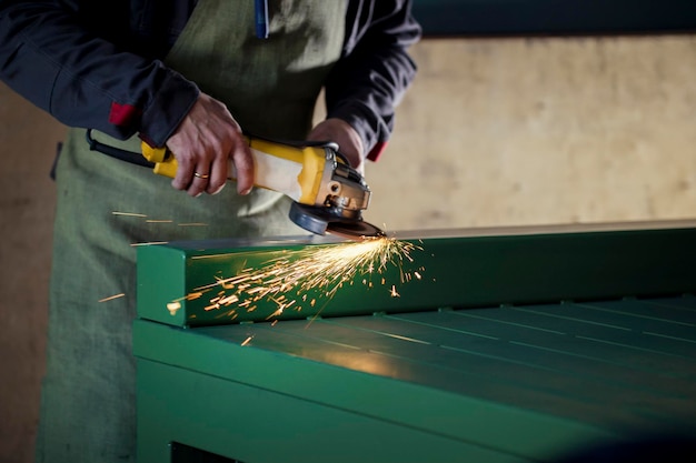 The worker grinding the steel mechanism on industry