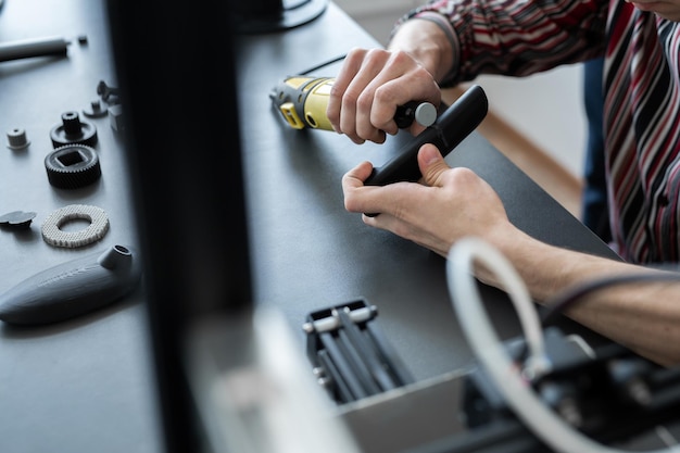 Worker grinds a finished 3D printer part