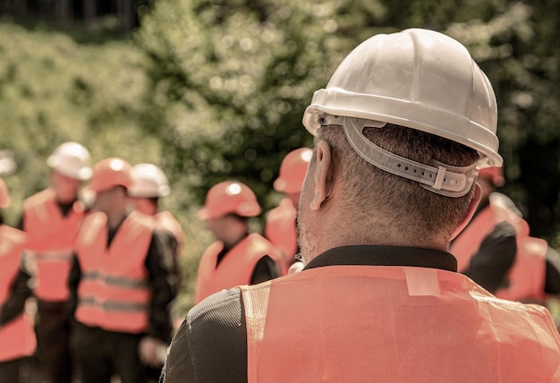 Фото Группа рабочих в защитном жилете концепция здания инженеры-архитекторы на строительной площадке строитель строитель в шлеме многие строители в шлеме