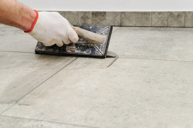 Worker grouting ceramic tiles