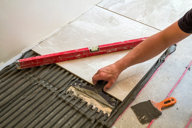 Worker hand installing floor tiles