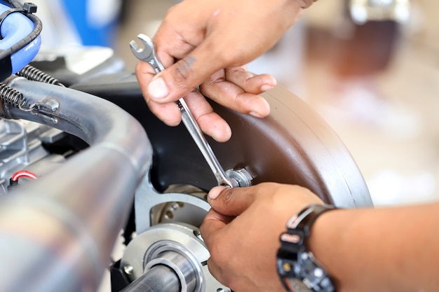 Worker hand tightening or loosening a nut of a bolt.