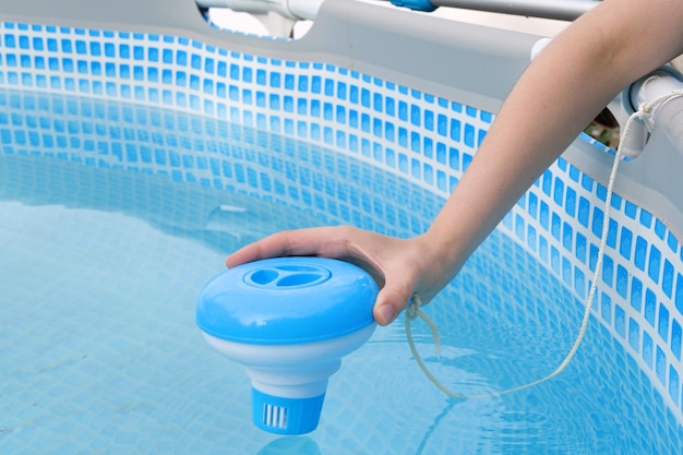 Worker hands isinfection and chlorination of water in the pool Purification from pollution pool chlor dispenser
