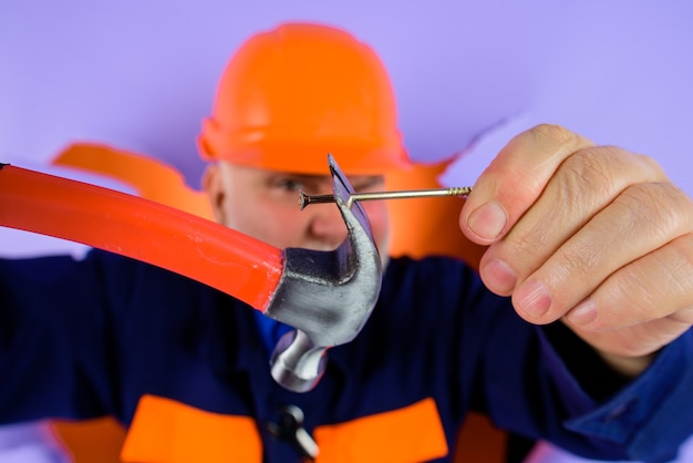 Worker in hard hat worker with hammer and nails repairman hammer and nails builder advertising