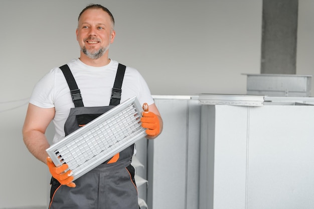 Worker holding air filter for installing in the office ventilation system Purity of the air concept