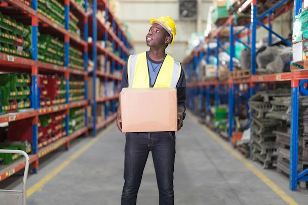 Worker holding boxes in warehouse to deliver