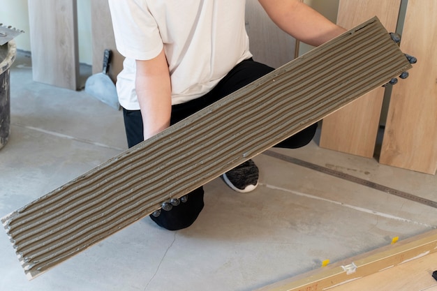 Worker holding tile with cement