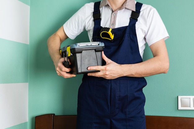 A worker holds a tool case on his shoulder