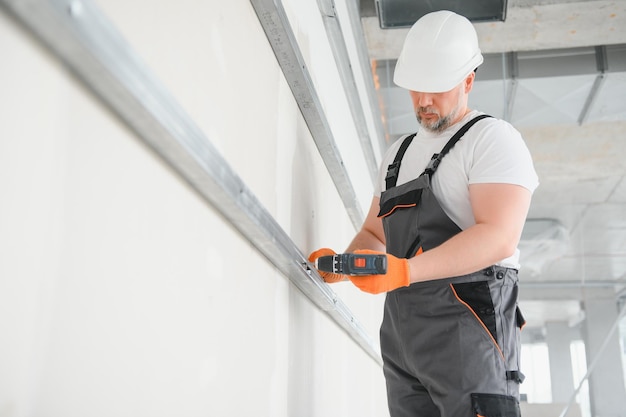 Worker install a plasterboard wall