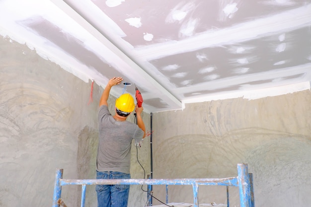 Lavoratore che installa il soffitto del bordo