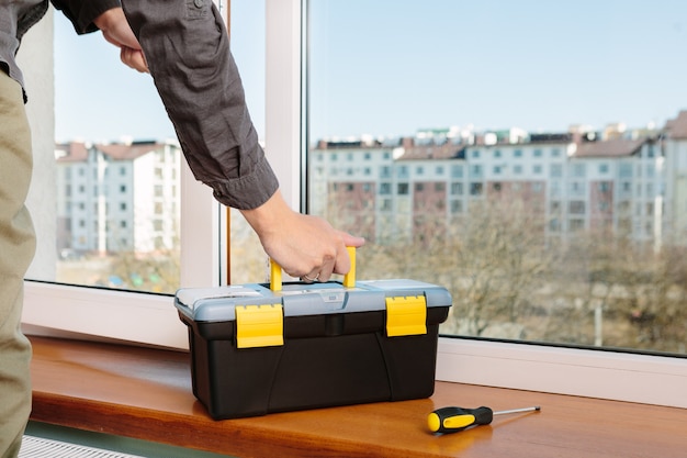 The worker installing and checking window in the house