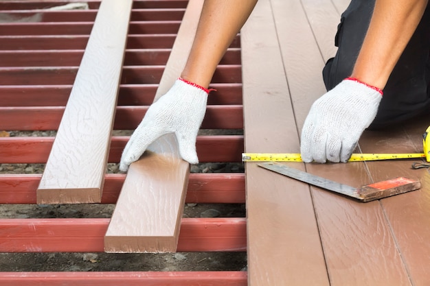 Worker installing wood floor for patio