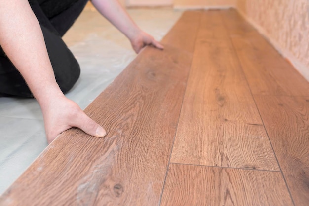 写真 労働者は木製の寄木細工の床の修理の概念をインストールします