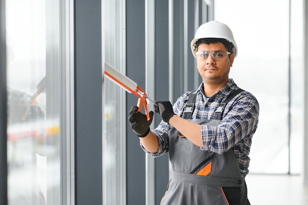 The worker installs a window frame in the room