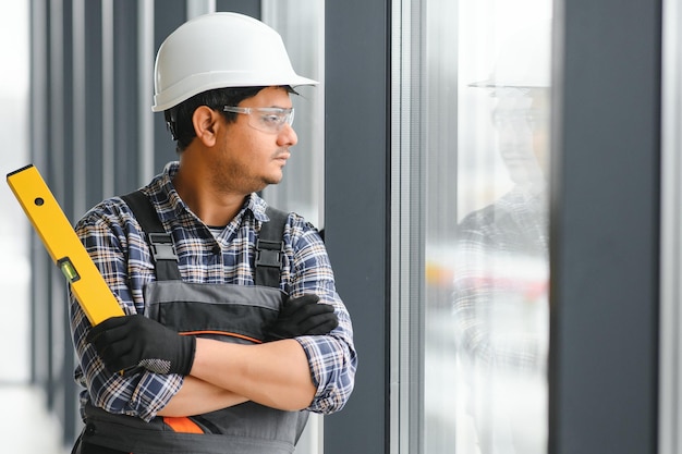 The worker installs a window frame in the room