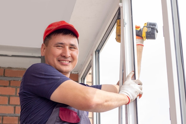 Worker installs windows master sverdit frame to attach to the base repair in highrise building