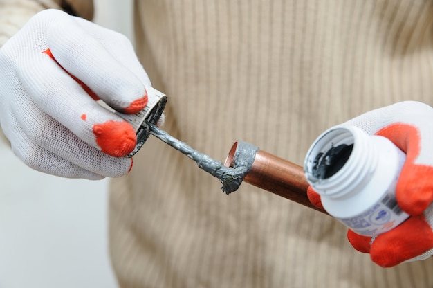 A worker is applying flux