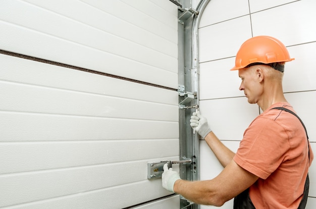 The worker is installing lift gates in the garage.