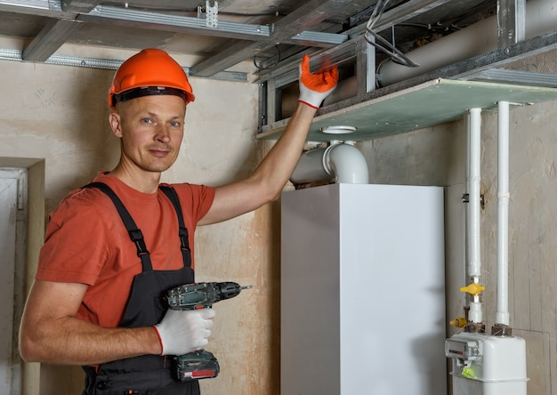 The worker is mounting a complex frame for drywall on the ceiling