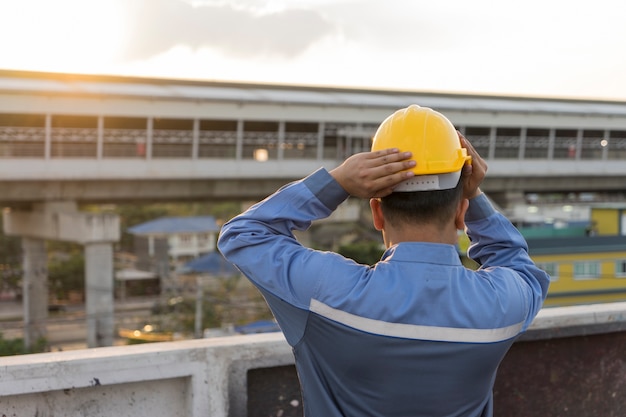 Worker is wearing his yellow helmet in the morning and ready to work.