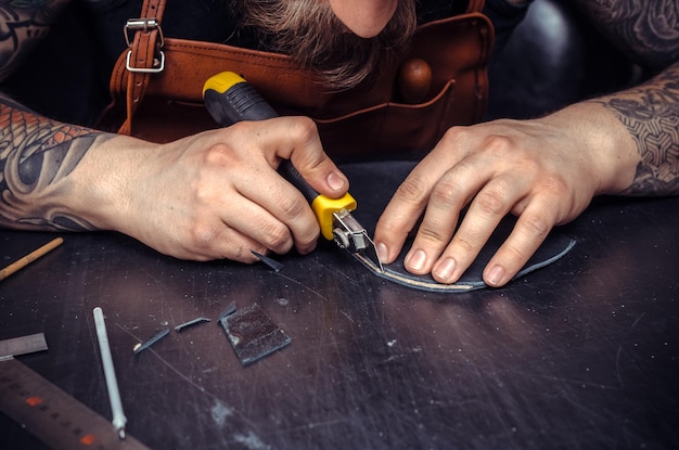 Worker of leather produces leather goods .