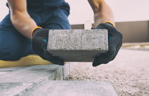 Worker lining paving slabs path