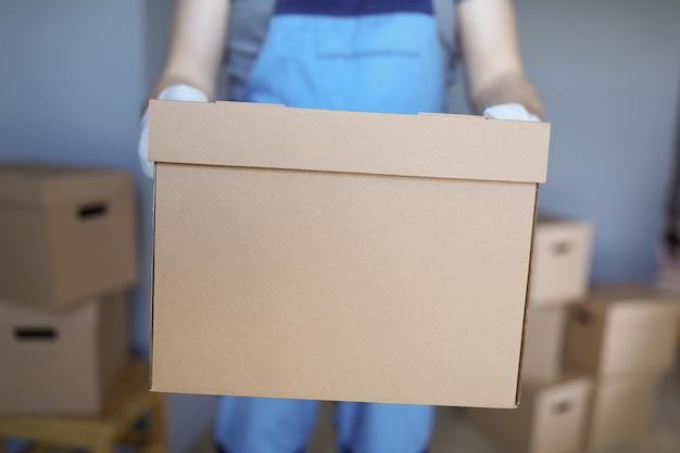 worker loading cardboard boxes with owners belongings to new apartment