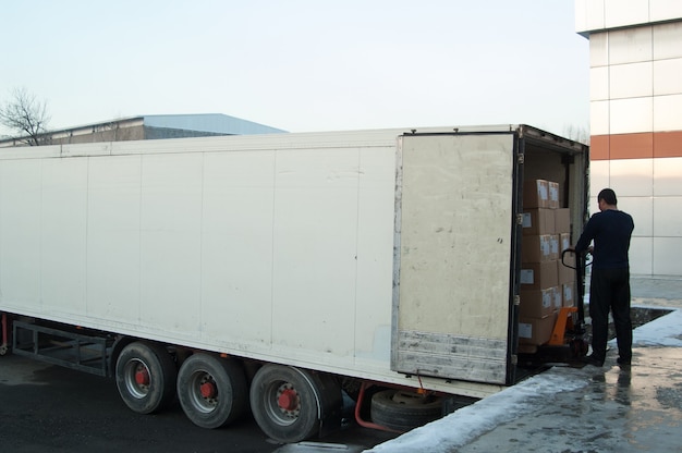 Рабочий загружает коробки в грузовик