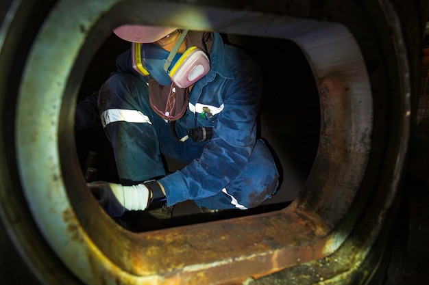 Worker male mask into the tank oil area inspection record tank\
confined space