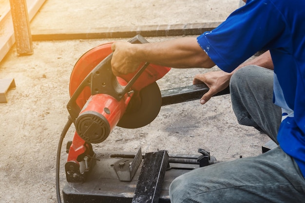 Worker man cutting steel with a circular steel cutter