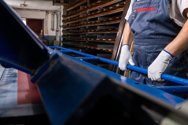 Foto l'uomo dell'operaio in fabbrica misura i lavori di produzione di metallo nell'industriale