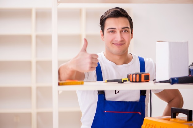 Worker man repairing assembling bookshelf