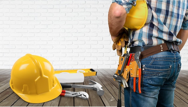 Uomo del lavoratore in uniforme con il casco sullo sfondo