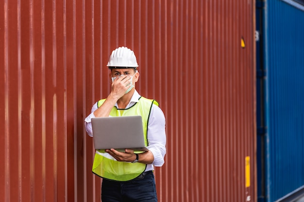 Worker man using a laptop waring surgical mask to protect for pollution and virus