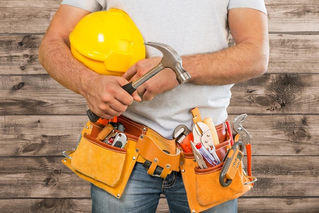 Worker man with helmet on construction background