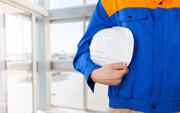 Worker man with helmet on construction background