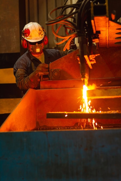 Worker managing an CNC oxy fuel cutting machine in a factory