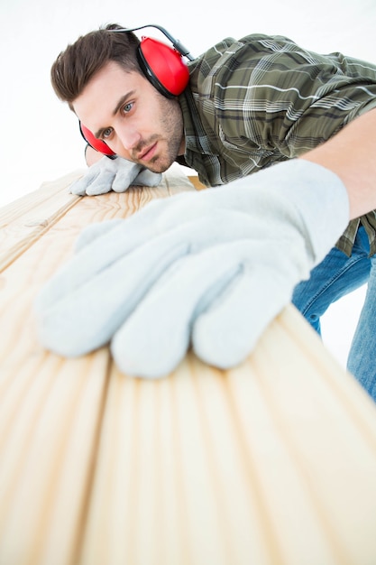 Photo worker measuring wooden plank