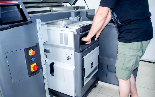 The worker moves the working camera of the d printer into the d printer large industrial d printer