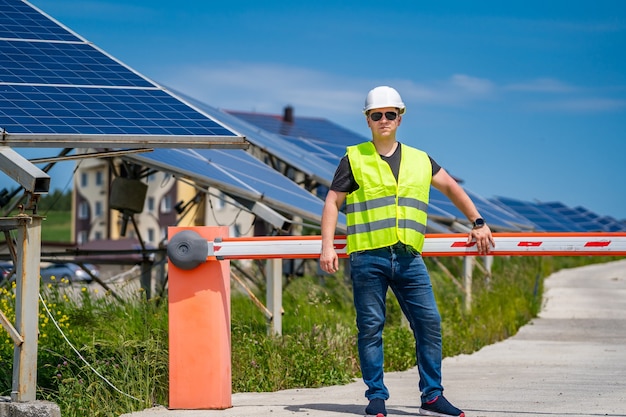 Operaio in una nuova fattoria di base energetica. tecnico di ingegneria su sfondo di pannelli solari.