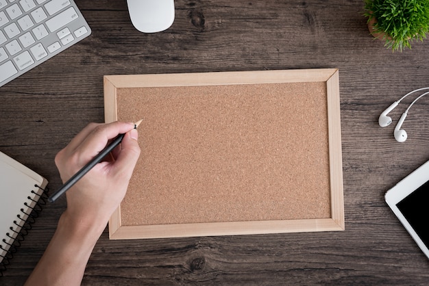 Photo worker at the office writing on cork board