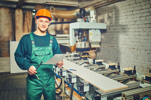 Worker operating computer controlled machinery in factory