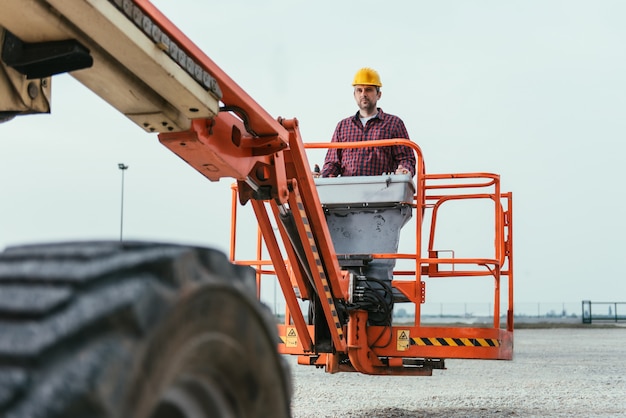 Worker operating Straight Boom Lift