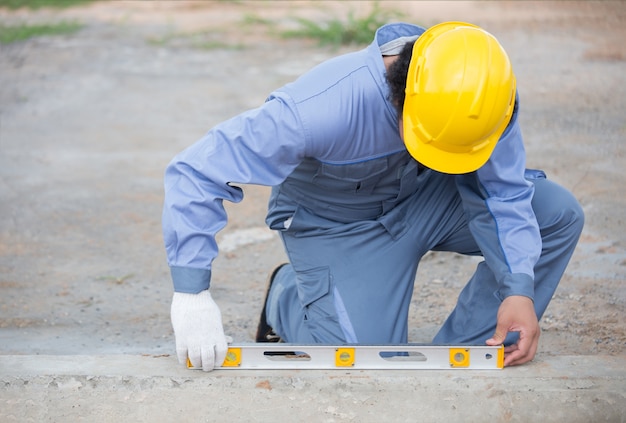 시멘트 측정을 위해 물 통치자 또는 게이지를 사용하여 작업 현장에서 작업자 또는 목수
