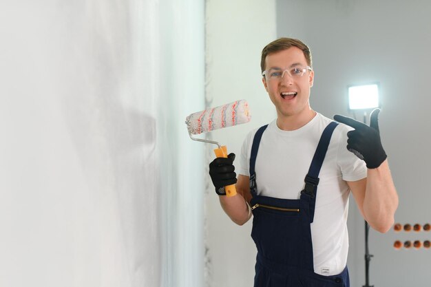 Foto il pittore operaio dipinge un muro il costruttore professionista effettua riparazioni
